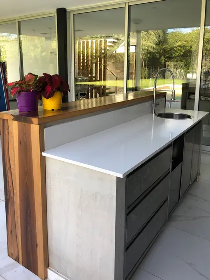 Cocina moderna con isla central blanca y vistas al jardín — proyecto CASA SB, por DX ARQ