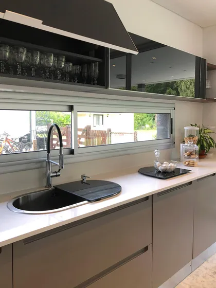Cocina minimalista con mesada blanca, pileta negra y ventanal grande — proyecto CASA SB, por DX ARQ