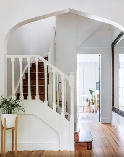 Escalera curva blanca con barandal de madera en doble altura — proyecto Olivos, por Biaus Pieres Arquitectura
