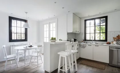 Cocina blanca moderna con isla, grandes ventanales y comedor integrado — proyecto Olivos, por Biaus Pieres Arquitectura