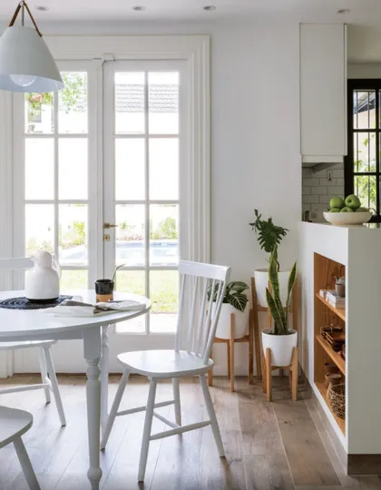 Comedor luminoso con mesa redonda blanca y puertas vidriadas hacia jardín — proyecto Olivos, por Biaus Pieres Arquitectura