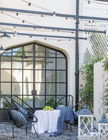 Terraza moderna con sillas de mimbre, mesita redonda y pérgola metálica — proyecto Olivos, por Biaus Pieres Arquitectura