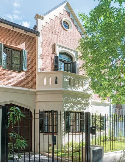 Fachada contemporánea de ladrillo con puerta metálica y enredadera verde — proyecto Olivos, por Biaus Pieres Arquitectura