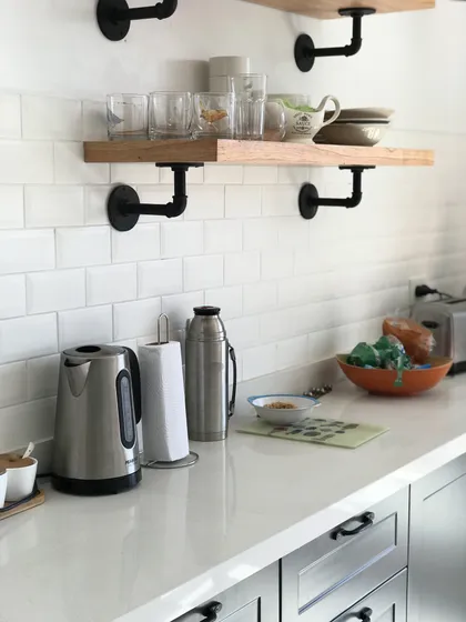 Cocina moderna con estantes flotantes de madera y soportes industriales negros — proyecto Peña, por Biaus Pieres Arquitectura, en Recoleta