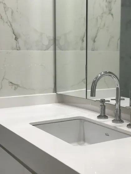 Baño con mesada de mármol blanco, espejo y grifo cromado — proyecto Paraná , por Biaus Pieres Arquitectura, en CABA