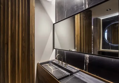 Bano moderno con mesada de marmol negro y detalles en madera — proyecto Casa India , por Estudio Simbiosis