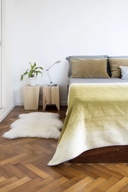 Dormitorio escandinavo con cama gris, textiles amarillos y piso de parqué — proyecto Departamento Barrancas, por Ekaterina Kunzel Arquitecta, en Belgrano
