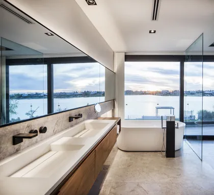 Baño moderno con vista al mar, doble bacha y bañera exenta — proyecto Casa Buddha, por Estudio Simbiosis