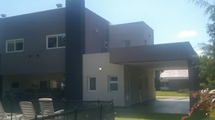 Fachada moderna de casa con pérgola y patio — proyecto Casas Golfers, por Arquitecto Oscar Sanguineti, en Pilar