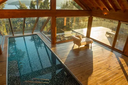 piscina interior-exterior con vistas al bosque — proyecto Casa Villa La Angostura, por Sidoni & Asociados, en Villa La Angostura