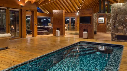 Piscina interior moderna con vigas de madera y piedra — proyecto Casa Villa La Angostura, por Sidoni & Asociados, en Villa La Angostura
