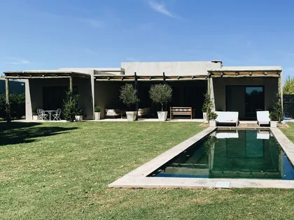 fachada moderna con piscina y césped extenso — proyecto Pilará 68, por Detry Miguens Arquitectura, en Pilará