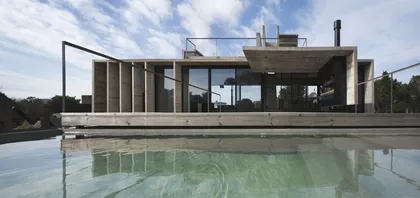 Casa moderna con pileta de agua cristalina reflejando la arquitectura — proyecto Casa Cariló, por Luciano Kruk, en Cariló