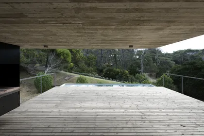 Terraza con deck de madera, pileta y vistas al bosque nativo — proyecto Casa Cariló, por Luciano Kruk, en Cariló