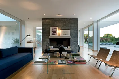 Sala de estar moderna con chimenea de piedra y grandes ventanales — proyecto OX8 - Casa en Martindale, por MLS Estudio, en Martindale Country Club