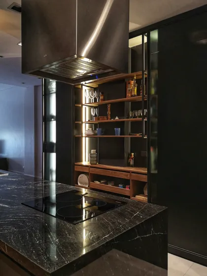 Cocina moderna con isla negra, campana industrial y estanterías abiertas — proyecto Dpto Callao, por T+T Arquitectos, en CABA
