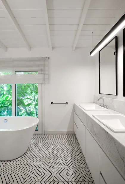 Baño moderno con bañera exenta y suelo geométrico — proyecto Casa BA, por Estudio Dado, en Pilar