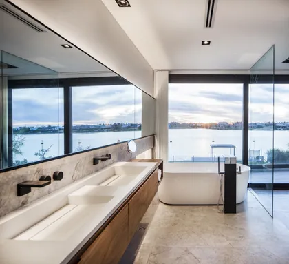 Baño moderno con vista al mar, lavamanos doble y bañera exenta — proyecto 242, por Remy Arquitectos