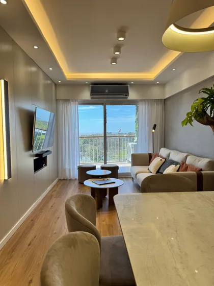 Living moderno con sofá curvo y luz indirecta — proyecto Libertador II, por MDBK Arquitectura, en Núñez