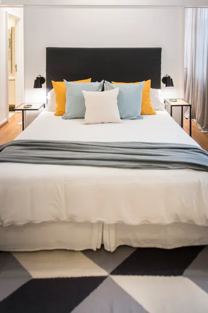 Dormitorio moderno con cama king, alfombra geométrica y detalles coloridos — proyecto Las Heras , por Claraboia , en Recoleta