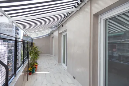 Terraza moderna con toldo a rayas y piso de madera — proyecto Obra Azcuenaga I, por Arq. Lourdes Yarade Saravia, en Buenos Aires