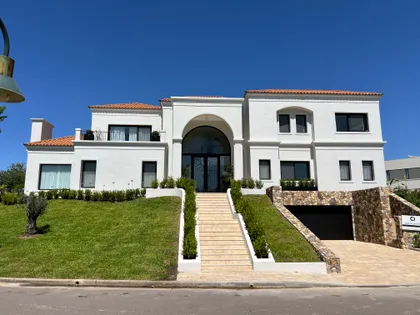 Casa moderna blanca con fachada curva, jardin y escalinata de acceso — proyecto CASA LR 456 - SOFITEL LOS CARDALES, por Carolina Depetris, en B2814 Los Cardales
