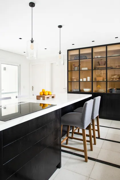 Cocina moderna con isla, gabinetes oscuros y luces colgantes — proyecto Santa Maria De Tigre, por Parq Estudio, en Tigre