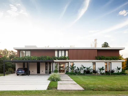 Fachada moderna con revestimiento de madera, concreto y amplios ventanales — proyecto CASA HS143, por A'PRIMA - Arquitectura Sustentable, en km 7.5 Ruta 25
