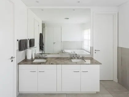 Baño moderno con doble lavabo, encimera de mármol y amplios armarios blancos — proyecto REFORMA GDLT, por Rastro Estudio, en Nordelta