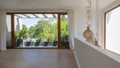 Living moderno con amplias ventanas y terraza verde — proyecto CASA BaCa, por Alfredo Orfila arquitectura, en Benavidez