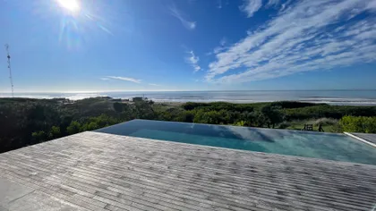 piscina infinita moderna con vista al mar — proyecto CASA sobre el MAR, por Guerrero Arquitectos, en Pinamar