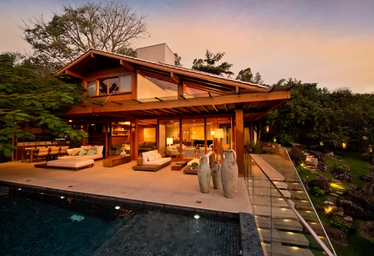 Casa moderna con pileta y terraza de madera al atardecer — proyecto Casa A.L., por Ruschel Arquitetura e Urbanism