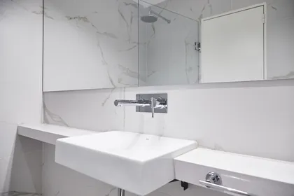 Baño moderno minimalista con bacha de losa y grifería de pared — proyecto UGARTECHE, por Estudio Trama, en Palermo