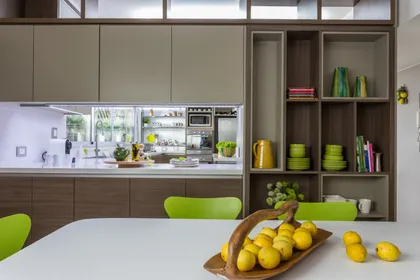 Cocina moderna con isla, muebles de madera y sillas verdes — proyecto Piso en Belgrano II, por Gutman+Lehrer Arquitectas, en Belgrano