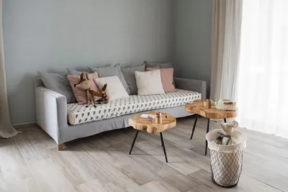 Sala de estar escandinava con sofá gris y mesas de madera — proyecto GBA 2 2016, por Mesopotamia Ba