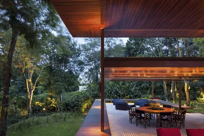 Galería moderna con techo de madera y vista al jardín arbolado — proyecto Residência GS, por Gil Fialho