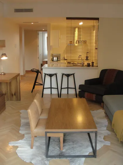 Sala de estar y cocina abierta con suelo de madera y alfombra de vaca — proyecto Departamento JD, por Vicky Hurrell, en Mar del Plata