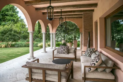 Galería cubierta con arcos, columnas y vista al jardín — proyecto CasaLA, por Ricardo Pereyra Iraola
