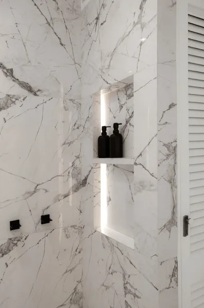 Baño moderno con paredes de mármol blanco y ducha empotrada — proyecto Alvear | Redefining luxury, por Ren Studio, en Recoleta