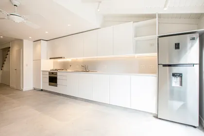cocina moderna integrada a living, con muebles blancos — proyecto Obra Martinez A, por Arq. Lourdes Yarade Saravia, en Martínez