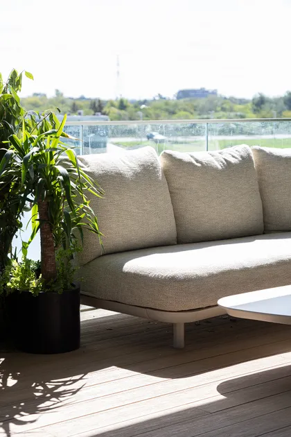 Sofá modular beige en terraza con deck de madera y vista urbana — proyecto C'est Moi , por Gaby Alfonso, en B1648 Tigre