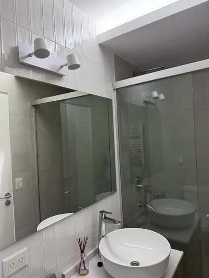 Baño moderno con bacha redonda, espejo grande y luces minimalistas — proyecto PH CASI, por Estudio Grupo 32, en San Isidro
