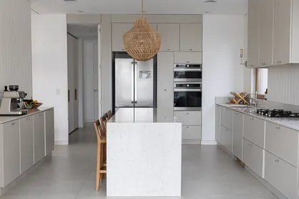 Cocina moderna escandinava con isla grande y lámpara de mimbre — proyecto Casa Al Agua - Grupo PAUTA, por Gaby Alfonso, en Belén de Escobar