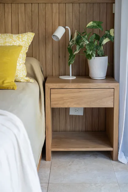 Habitación con pared de madera, mesa de luz y planta — proyecto Bustamante, por Blue Rabbit Design, en Palermo