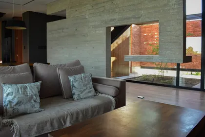 Living moderno con hormigón visto y patio de ladrillos — proyecto CASA HC, por Daniel Daniele - Oficina de Arquitectura, en Canning