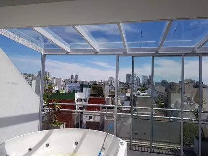 terraza con jacuzzi y techo vidriado con vista a la ciudad — proyecto Cerramiento aluminio Modena en terraza, por Cristalcenter, en Palermo