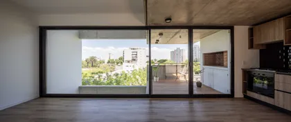 Living moderno con cocina y balcón con parrilla exterior — proyecto Terrazas de Malvinas, por DREI Arquitectura y Desarrollos, en La Plata