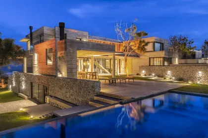 villa moderna con piscina infinita al anochecer — proyecto CASA sobre el MAR, por Guerrero Arquitectos, en Pinamar