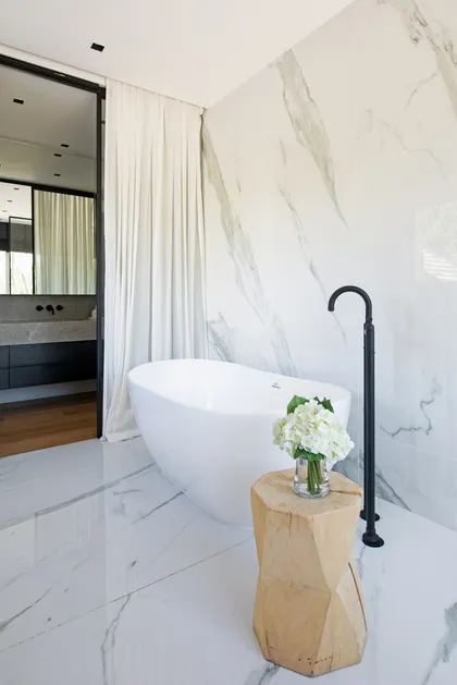 Baño moderno con bañera exenta, mármol y detalles de madera — proyecto Santa Maria De Tigre, por Parq Estudio, en Tigre