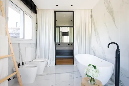 Baño moderno con bañera exenta, mármol blanco y mucha luz natural — proyecto Santa Maria De Tigre, por Parq Estudio, en Tigre